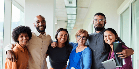 group of professionals standing arm in arm