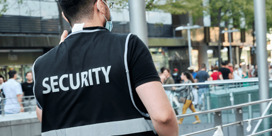 back view of a security guard wearing a vest with security across it