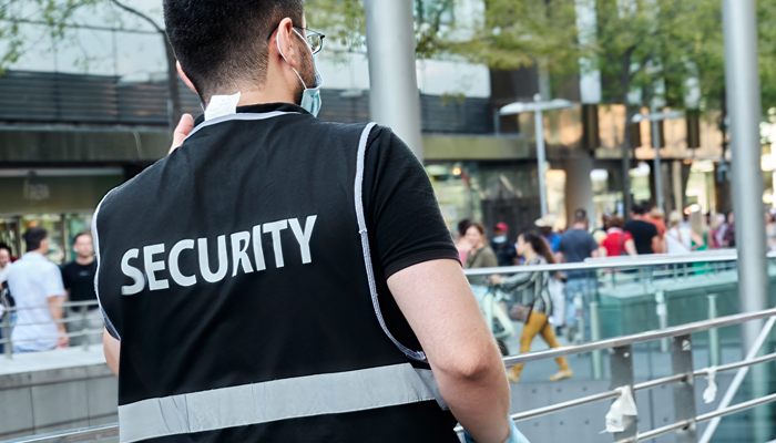 back view of a security guard wearing a vest with security across it