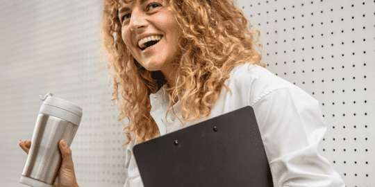 business woman holding a thermo cup and clipboard at her job after completing a social media check