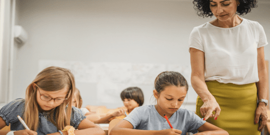 teacher and student in classroom setting after signifying the necessity of a vulnerable sector check