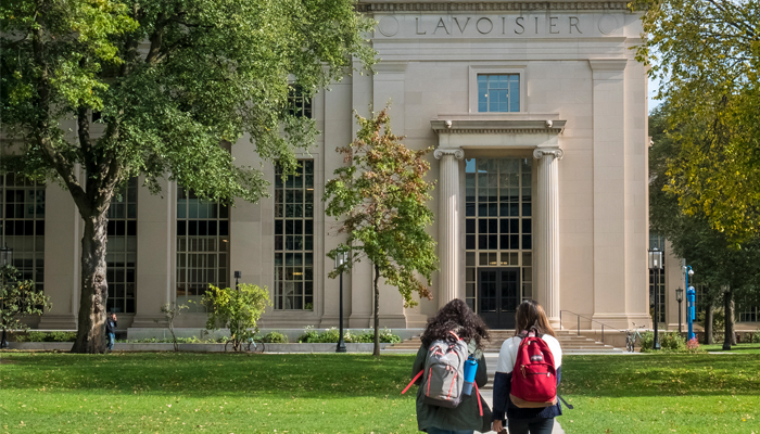 image of 2 students walking towards a university signifying safety and why social media background checks can help