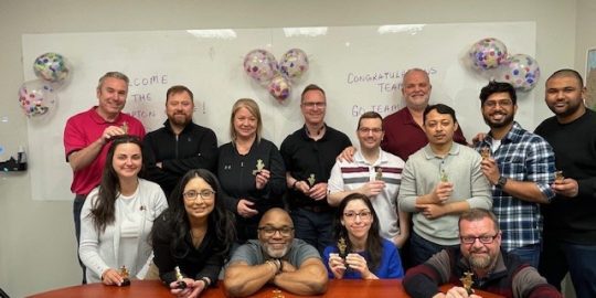 photo of the Triton team surrounding a desk looking forward