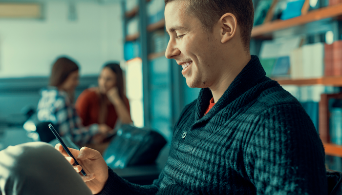 image of man smiling at his phone showcasing hiring discrimination example