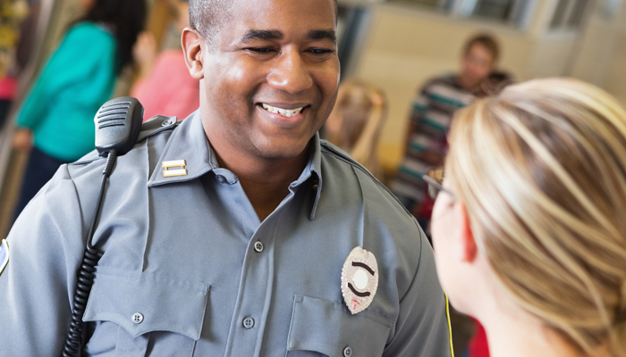 security guard smiling to a woman. This image signifies a security guard position